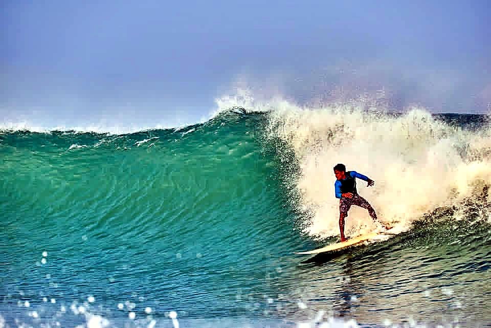 A surfer trimming along a long, clean wall at Arugam Bay