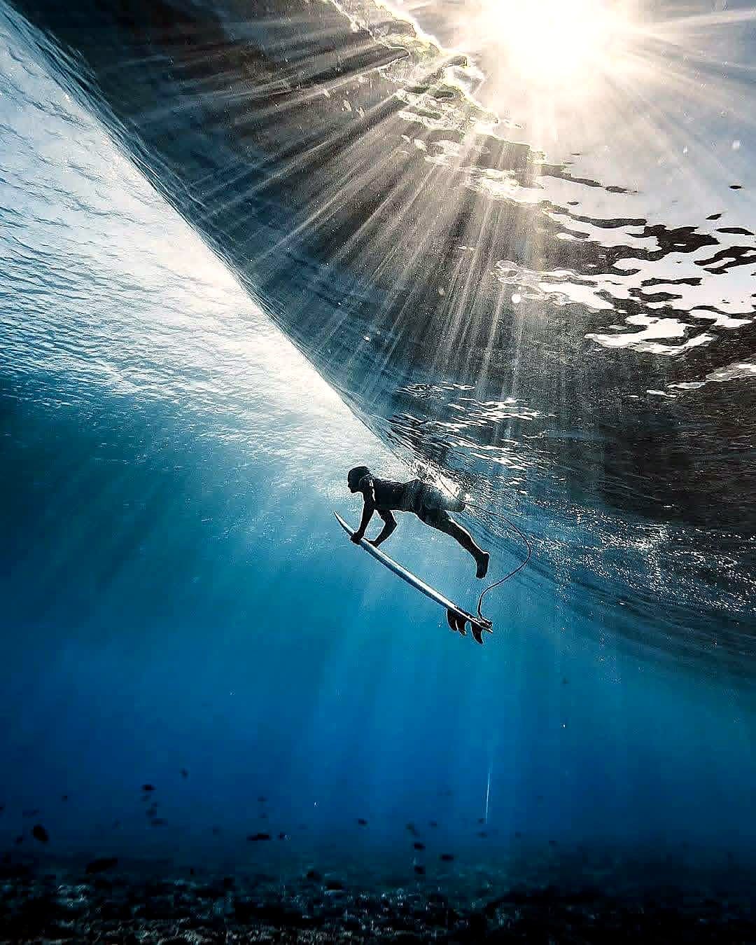 Underwater view of a surfer duck-diving beneath a wave